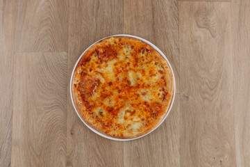 mix cheeses pizza with meat vegetables on a wooden background
