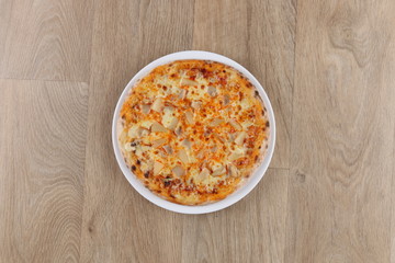 Hawaiian pizza pizza close up on a wooden background - pineapple