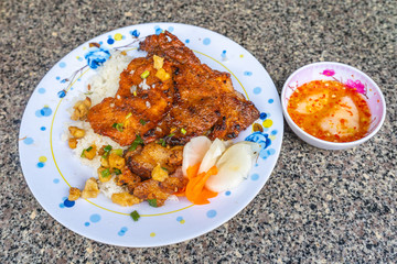Plate of delicious Vietnamese pork chop rice and chili sauce