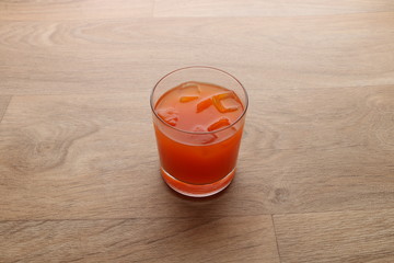 cocktail juice ice in a glass cup on a wooden background