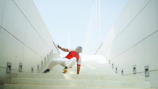 Attractive man dancing hip hop on the stair outdoors. Shot in 4k resolution