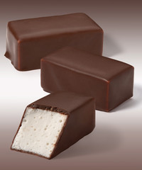 Candies whipped Cream in chocolate on a white brown background