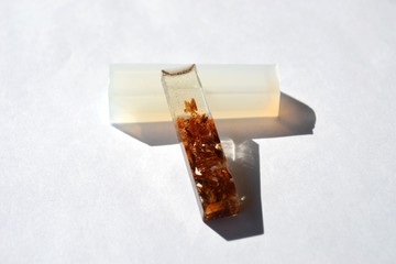 Wooden shavings in epoxy resin block. White silicone mold isolated on white background. Handmade jewelry.