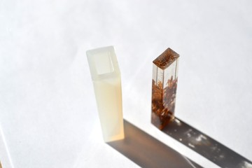 Wooden shavings in epoxy resin block. White silicone mold isolated on white background. Handmade...