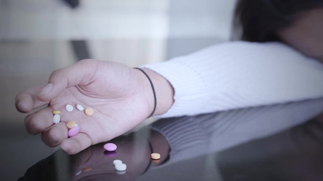 Drug addict hand holding drugs or narcotics on the table at home. Shot in 4k resolution