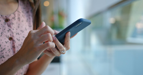 Woman use of smart phone inside office background