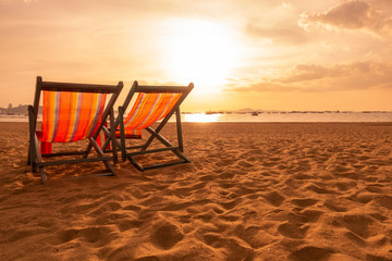 A couple canvas beds on the beach with sunset light atmospher