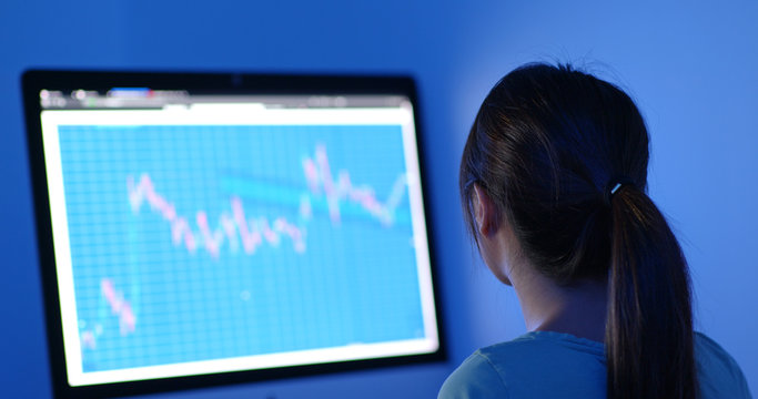 Woman study on stock market data at night