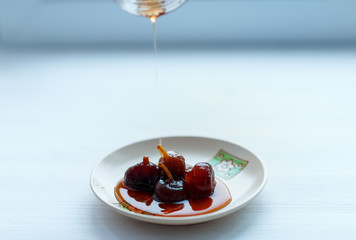 Fig jam on a light plate on a white background, shot in the light from the window