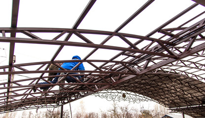 A worker mounts a metal canopy