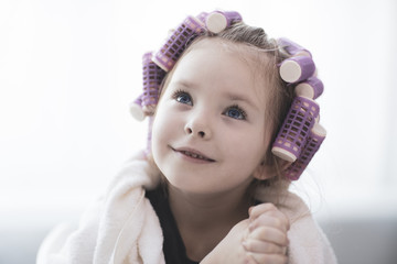 Girl with curlers hairpins in her hair.