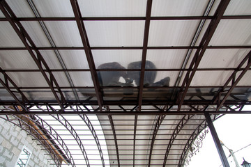 A worker mounts a metal canopy in the courtyard of the house