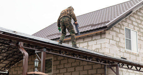 A worker mounts a metal canopy