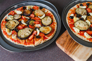 pizza base with tomato sauce veggies and aubergine before going in the oven