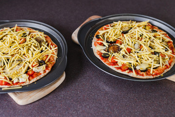 vegetables pizzas with vegan cheddar topping before going in the oven