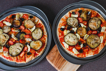 pizza base with tomato sauce veggies and aubergine before going in the oven