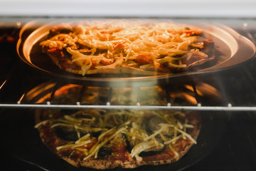 vegetables pizzas with vegan cheddar topping in the oven