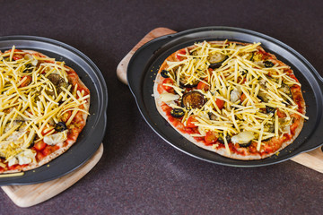 vegetables pizzas with vegan cheddar topping before going in the oven