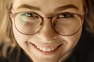 Portrait of a smiling face of a young girl in glasses close up