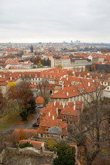 Naklejka na ściany i meble Panorama of the Czech city of Prague with tiled orange roofs from the observation deck of Prague Castle on a cloudy day on the eve of Christmas.