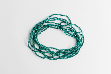 Naklejka premium Vivid green colored plastic beads isolated on white, ready to be used for handmade objects and projects, photographed with selective focus