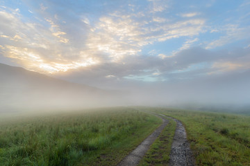 Fototapeta na wymiar Single track road disappear in the morning mist