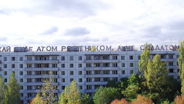 Aerial view of house labeled "&rsquo;ай буде атом робiтником, а не солдатом" in Pripyat town. Aerial shooting abandoned architecture of ghost city