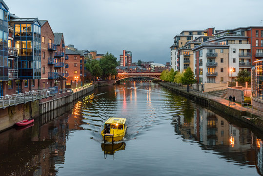 The River Aire in the centre of Leeds, West Yorkshire, England, UK, with apartment buildings on either side, some converted ware