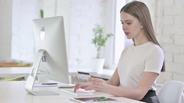 Young Woman Celebrating Online Payment Success on Desktop