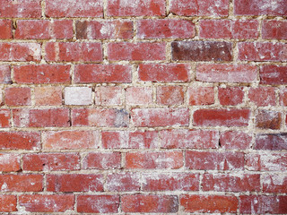 Close up of an old vintage red brick wall with old worn white plaster texture background