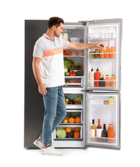 Man taking juice from refrigerator on white background