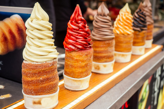 woman with an appetite eats a traditional Czech sweet Trdelnik in Prague street