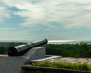 A view of an old cannon facing out to the strait of malacca