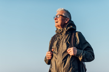 Old man trail hiking in a mountain forest.