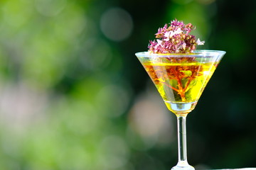 glass of champagne and flowers on red background