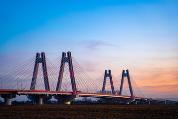 Fototapeta na wymiar Monumental, lighted, new modern double cable-stayed bridge over Vistula River in Krakow, Poland during sunset.