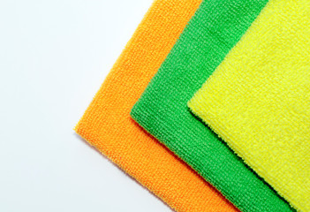 Yellow, green, orange towel on a white background. House cleaning concept