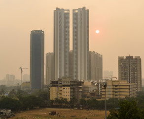 Fototapeta na wymiar The sun sets behind the high rises of the North Mumbai suburb of Kandivali East.