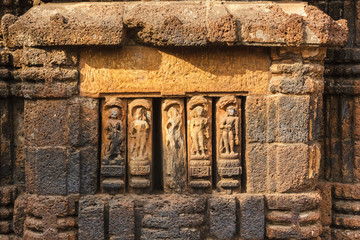 The artfully carved figurines on the laterite walls of an ancient Hindu temple in the city of Bhubaneshwar in Orissa, India.