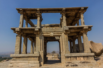 Hampi, Karnataka, India - December 10, 2013: A ruined double-storeyed structure made of stone on the Hemakuta hill in the archaeological ruins of the UNESCO heritage site in Hampi.