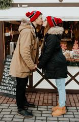 couple strolling at the christmas market. man and woman in red hat