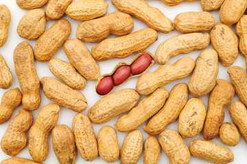 Peanuts background with one opened peanut nutshell containing three peanuts. In a nutshell concept. Openness concept. Nuts nutrition for an healthy and balanced long life