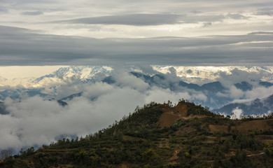 A view of the clouds hanging over the Annapurna range across the hills from the outskirts of the town of Tansen in Nepal.