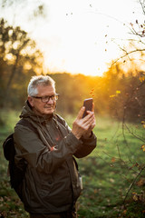 Old man doing selfie in sunset.