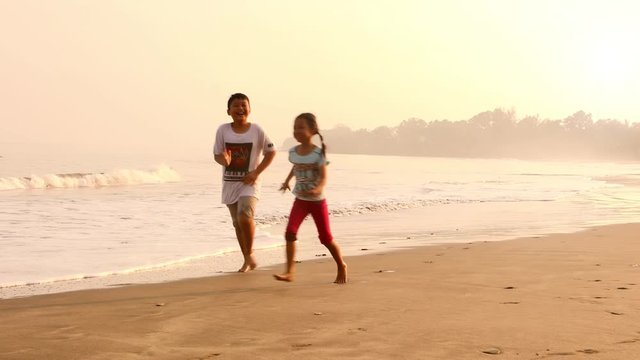 Children and mother doing run races on the beach