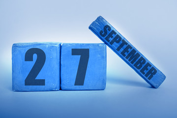 september 27th. Day 27 of month, Handmade wood cube calendar with date month and day in trendy classic blue color of the year autumn month, day of the year concept