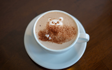 morning coffee. teddy bear latte art made with milk foam.cup of coffee on wooden table