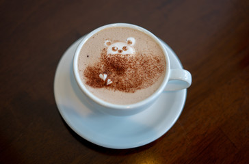 morning coffee. teddy bear latte art made with milk foam.cup of coffee on wooden table