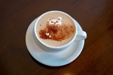 morning coffee. teddy bear latte art made with milk foam.cup of coffee on wooden table