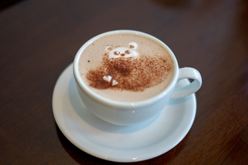 morning coffee. teddy bear latte art made with milk foam.cup of coffee on wooden table